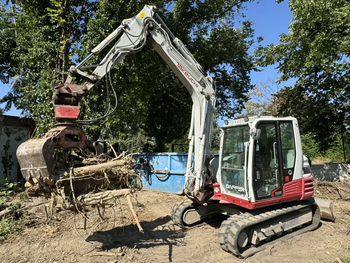 Bager Takeuchi pri manipulácii s koreňmi a čistení pozemku